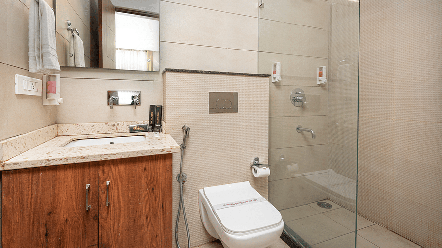 A deluxe room washroom featuring a large mirror and neatly arranged toiletries at DLS The Classio